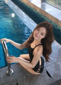 菲菲 163cm  B+奶  43kg  23歲    她站在泳池邊，濕髮黏在臉頰